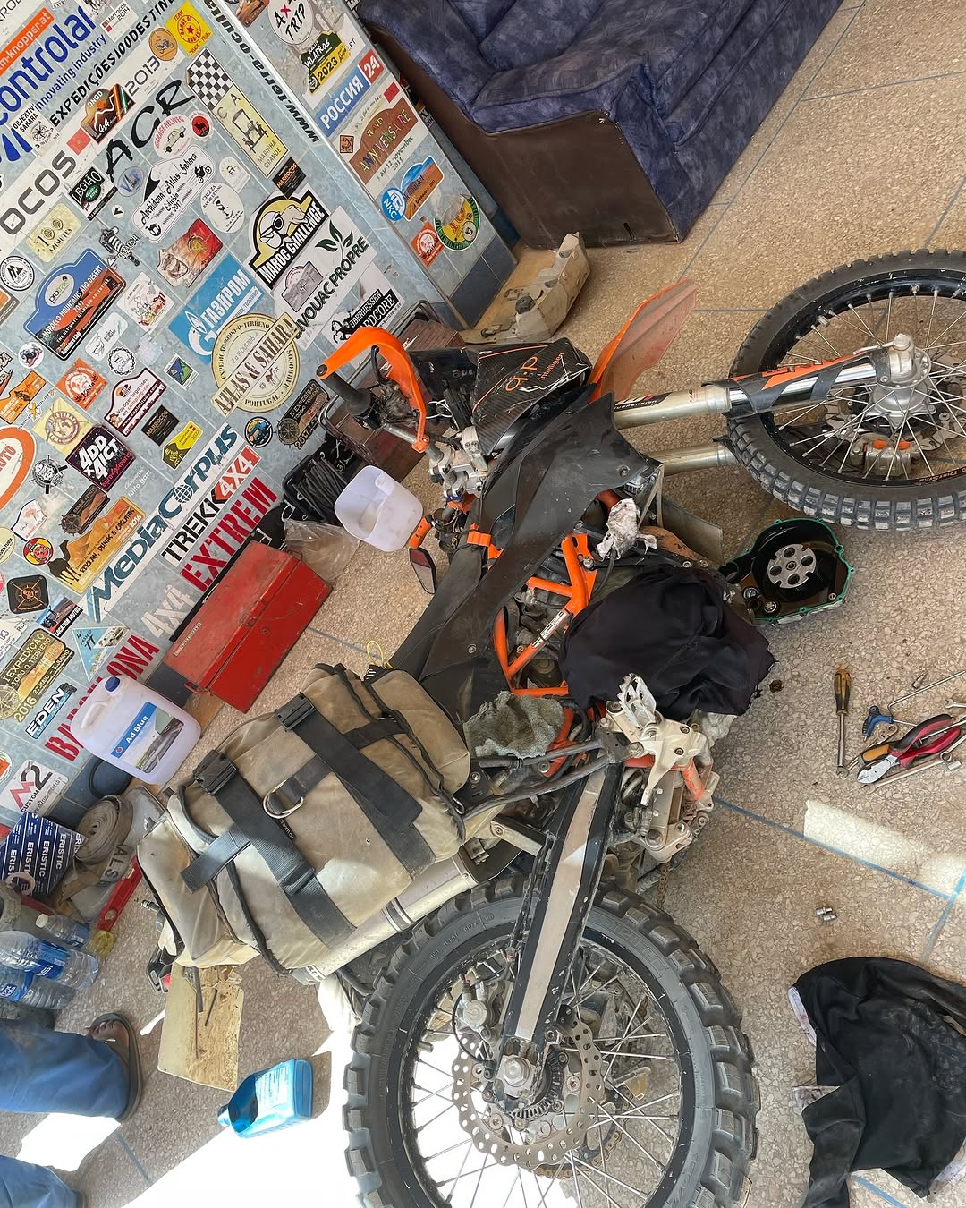 Top-down view of the KTM enduro with the clutch cover off and the removed clutch basket next to the bike