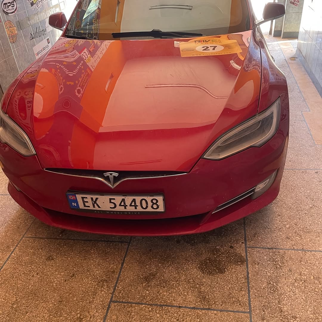 Close-up of the red Tesla Model S front with rally plate 27 after the front and rear ride-height lift