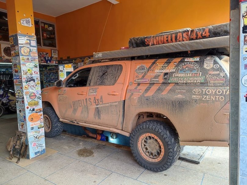 Second SinHuellas 4x4 Toyota Hilux from Argentina on the lift while a mechanic works underneath at Garage Iriki Zagora