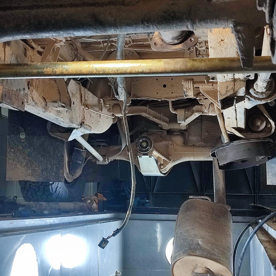 Under-chassis view of the Land Rover Defender with driveshaft removed for the gearbox job