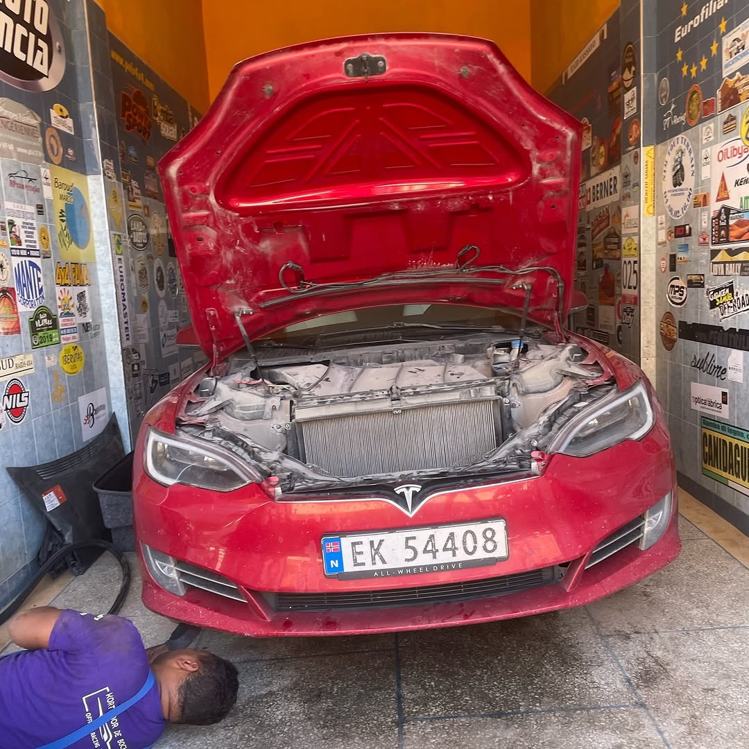 Tesla Model S front stripped with the radiator and cooling pack exposed during the ride-height lift work